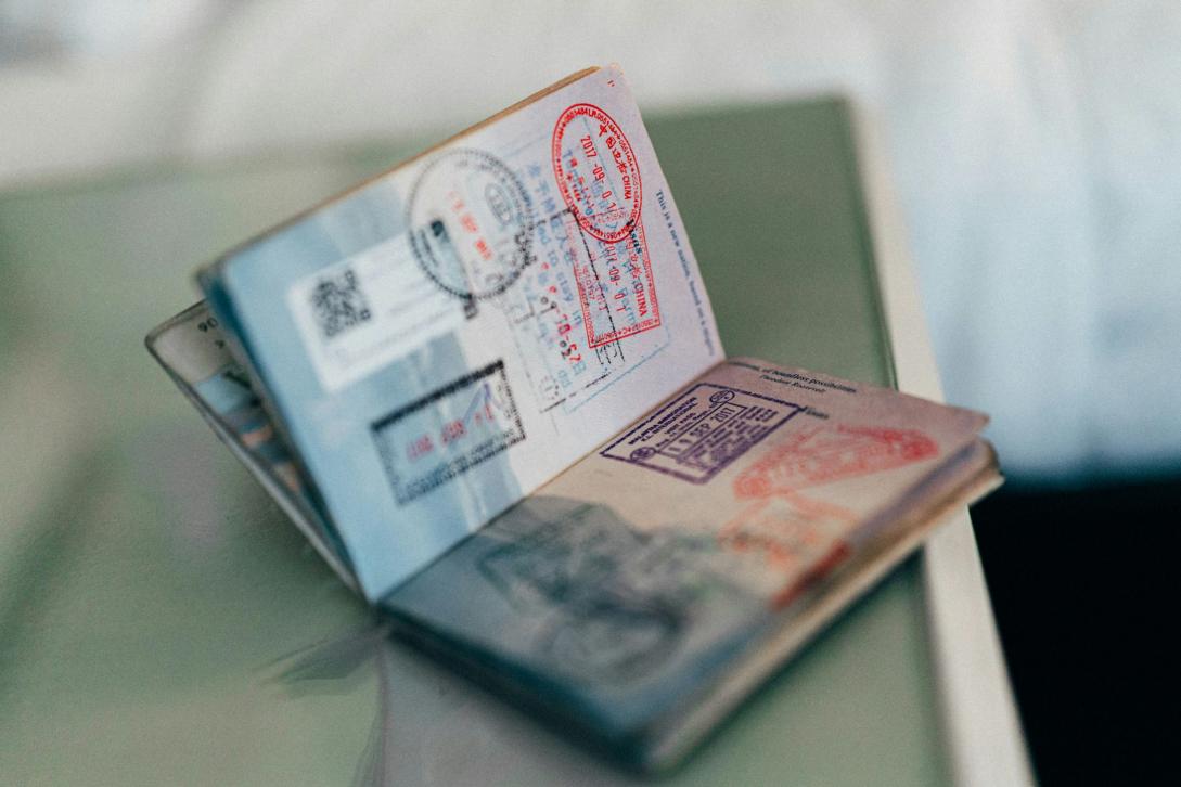 A passport filled with stamps sits open