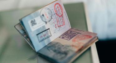 A passport filled with stamps sits open